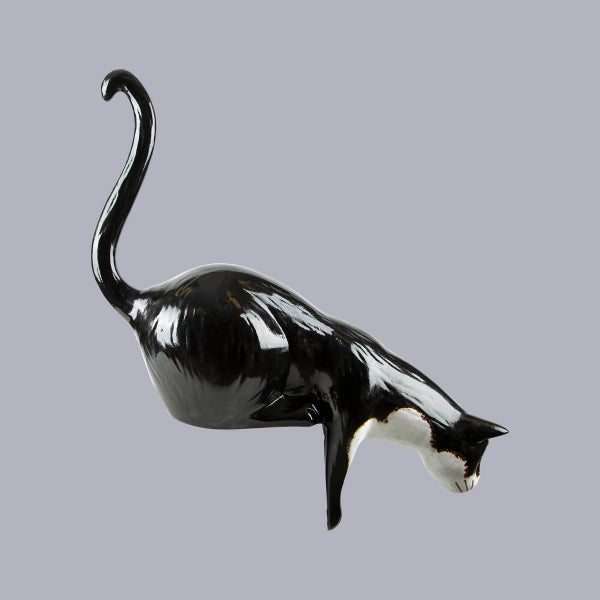 Dekofigur Katze aus glänzender Keramik in Schwarz und Weiß, hockend mit erhobenem Schwanz.