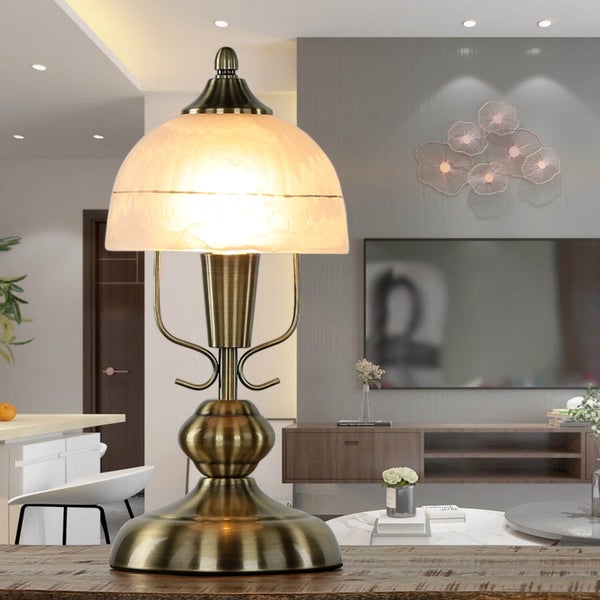 Tischleuchte mit Schirm und antikem Finish auf einem Tisch