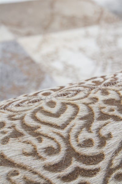 Nahaufnahme eines Fellteppichs mit Ornamentmuster und sichtbaren Nähten.