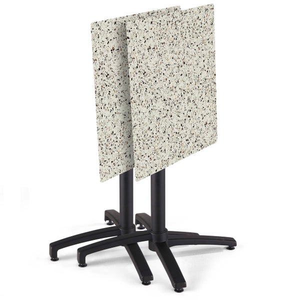 Zwei Bistrotische mit klappbaren quadratischen Tischplatten in Terrazzo-Optik und schwarzem Metallgestell.
