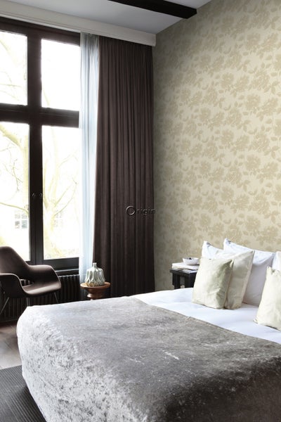 Schlafzimmer mit floral gemusterter Tapete, Bett und Fenster