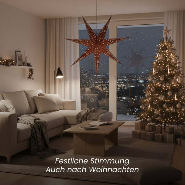 Wohnzimmer mit Sofa, Couchtisch, Weihnachtsbaum mit Dekoration und Papierstern