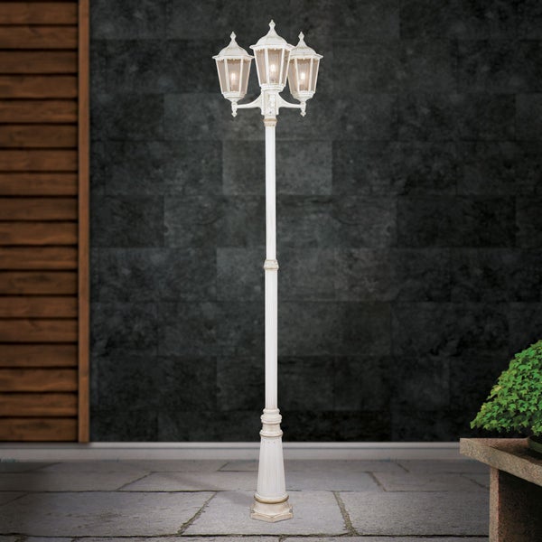 Dreiflammige klassische Außenleuchte im Laternendesign mit antikem Finish auf einer gepflasterten Terrasse.