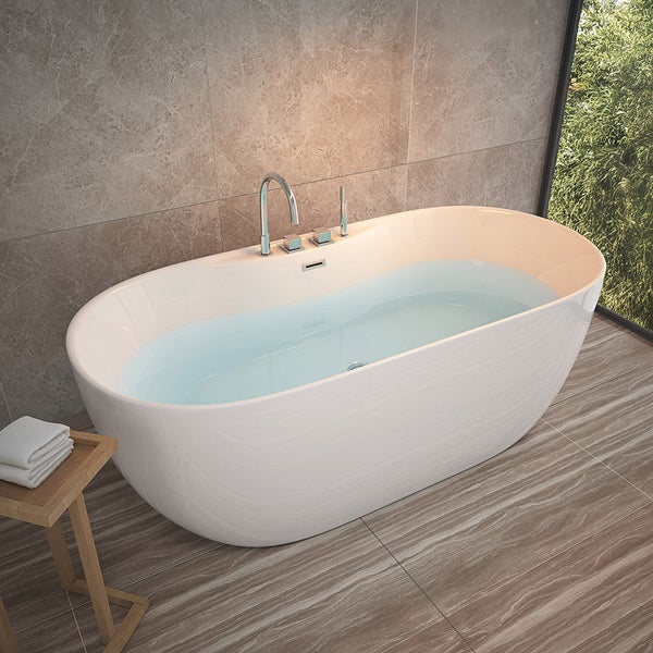 Freistehende Badewanne mit Armatur in einem modernen Badezimmer mit Fliesen in Steinoptik und Blick ins Grüne.