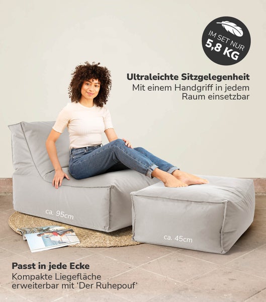 Szene mit einer gemusterten Tapete, einem Klavier, einer Lampe, einer Vase mit Blumen und einem Stuhl.