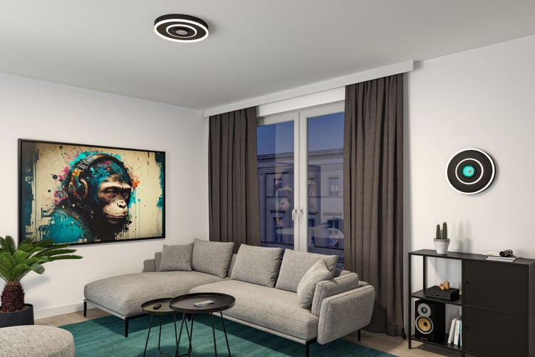 Modernes Wohnzimmer mit grauem Ecksofa, schwarzen Couchtischen, dunkelgrauen Vorhängen und runden LED-Decken- und Wandleuchten.