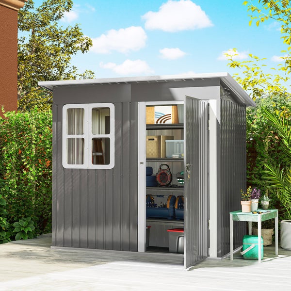Modernes Gartenhaus aus Metall mit Pultdach und Fenster, geöffnete Tür zeigt Regalsystem mit Werkzeug, auf einer Holzterrasse im Garten.
