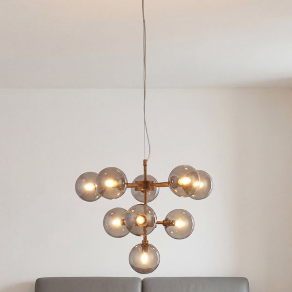 Moderne Pendelleuchte mit zehn Rauchglaskugeln an einem bronzefarbenen Metallgestell.