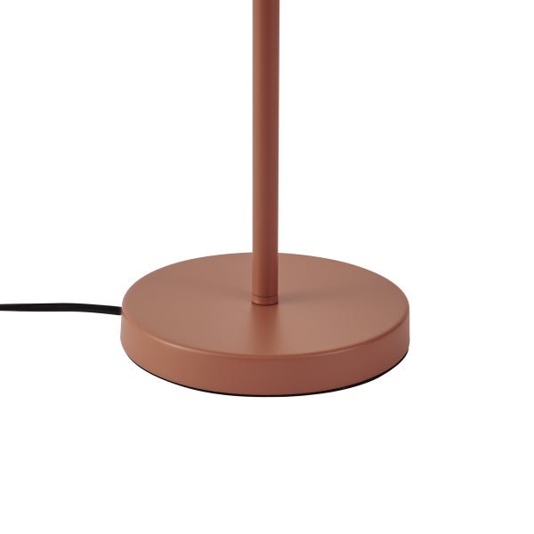 Runder Lampenfuß aus Metall in Terracotta mit schmalem Standrohr und schwarzem Stromkabel.