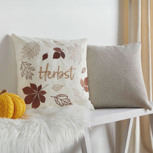 Dekokissen mit Herbstmotiven auf einer Bank