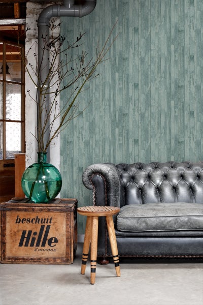 Wohnzimmer mit Sofa, Holzhocker und dekorativer Holzwand