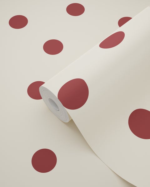 Vliestapete mit großen dunkelroten Punkten auf beigem Hintergrund als Rolle.
