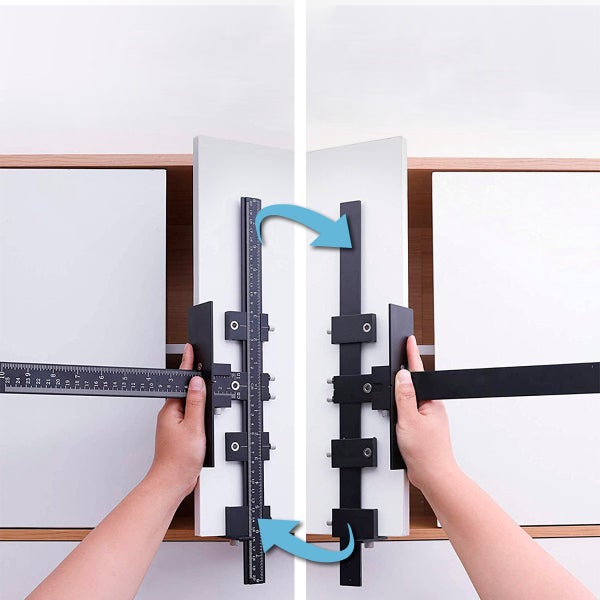 Bohrlehre für Möbelgriffe aus schwarzem Metall und Kunststoff, Anwendung an einer weißen Schranktür mit Zentimeter-Skala.