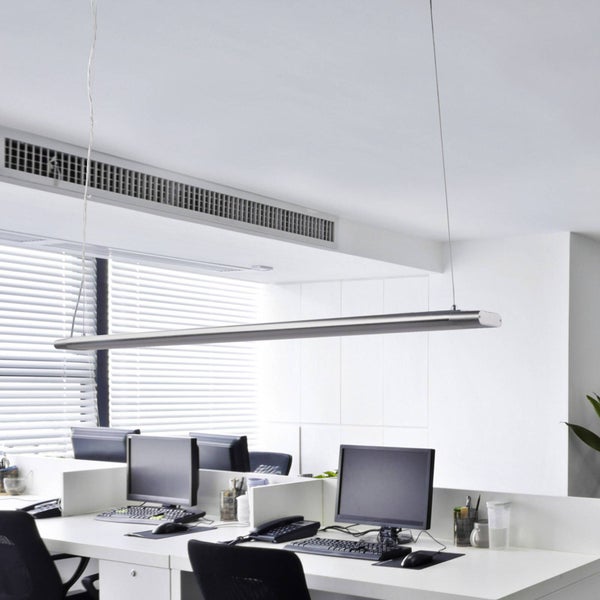 Moderne LED-Pendelleuchte über weißen Büroarbeitsplätzen mit Computermonitoren und Tastaturen in einem hellen, organisierten Büro.