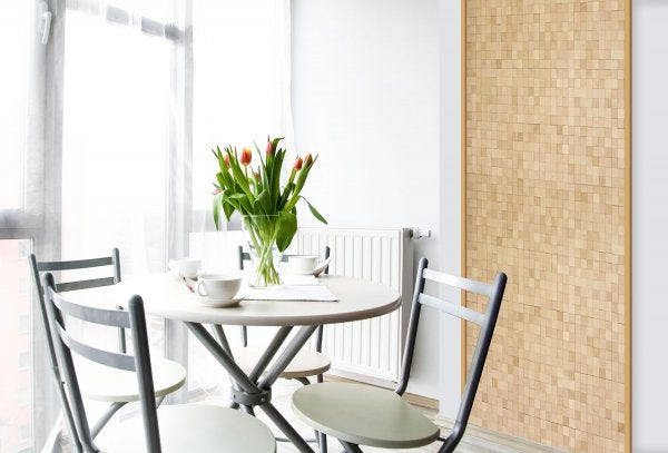 Heller Essbereich mit rundem Tisch, Stühlen, Tulpen in einer Vase und einer Wandverkleidung mit quadratischen Holzelementen