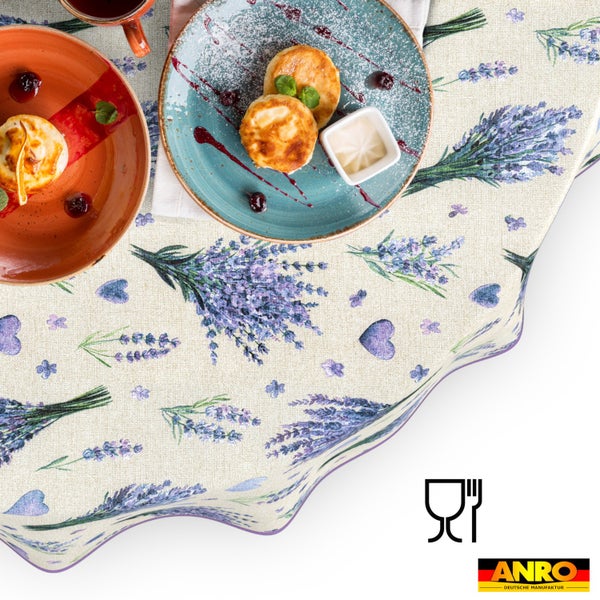 Tischdecke mit Lavendel-Blütenmuster und Herzmotiven, Frühstücksszene mit Tellern, lebensmittelecht, ANRO Deutsche Manufaktur Logo.