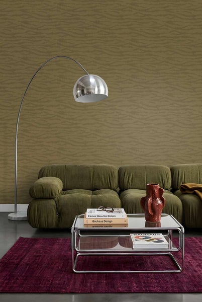 Wohnzimmer mit gemusterter Vliestapete, modernem Sofa, Bogenlampe und Glascouchtisch auf einem Teppich vor einer strukturierten Wand.