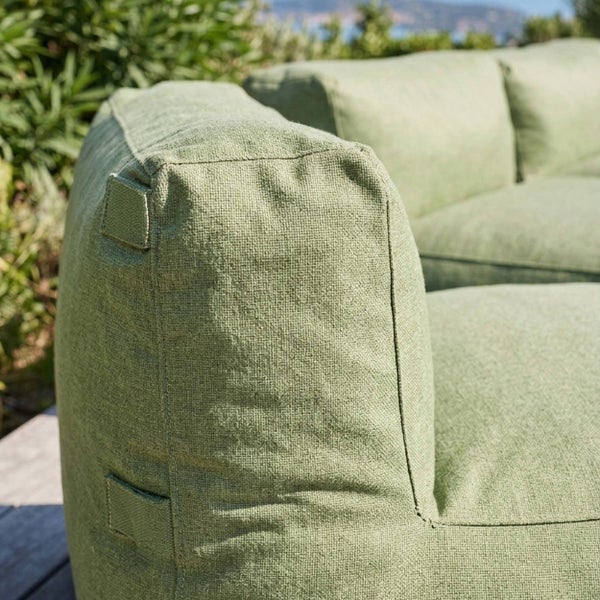 Detailansicht eines grünen Outdoor-Sitzsacks aus grob gewebtem Stoff mit seitlichen Befestigungslaschen für die Terrasse.