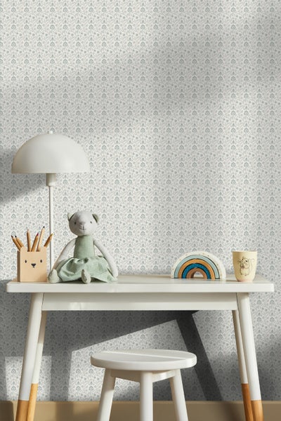 Kinderzimmer mit einem Schreibtisch, einem Stuhl und einer floralen Tapete.