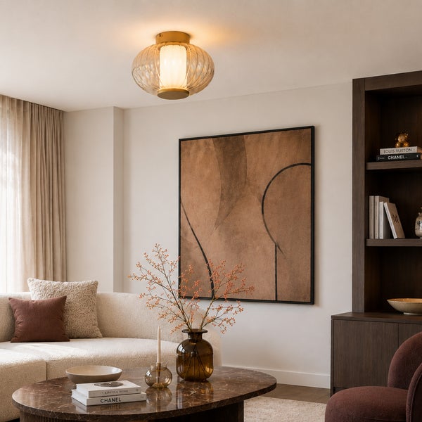 Moderne Deckenleuchte aus geripptem Glas und Messing in einem elegant eingerichteten Wohnzimmer mit Sofa und Couchtisch.