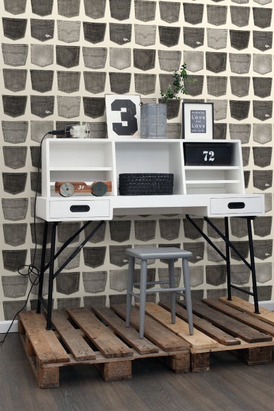 Zimmer mit Schreibtisch, Hocker und einer Wandtapete mit Jeanshosentaschenmuster