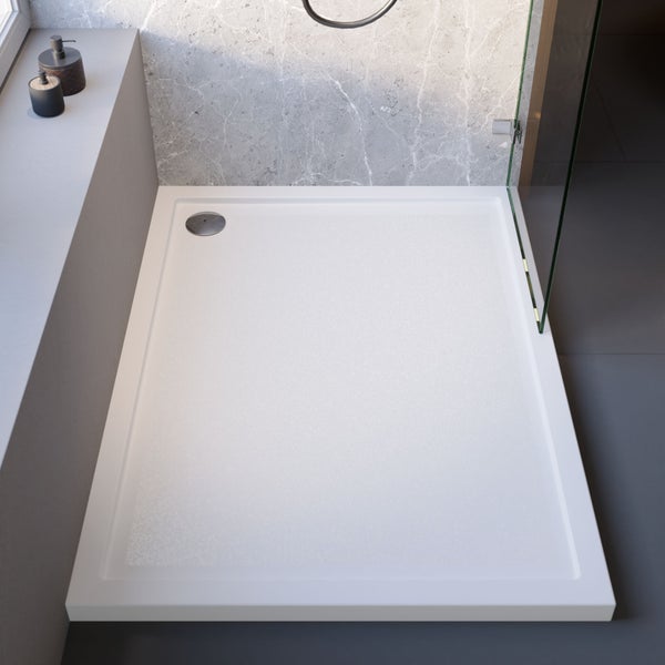 Weiße rechteckige Duschwanne in einer Dusche mit Glasabtrennung und Wand in Marmoroptik.