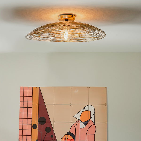 Deckenleuchte mit Metalldrahtschirm und dekorativem Bild an der Wand