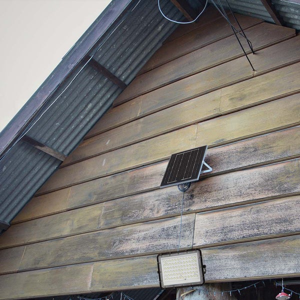 Solarstrahler an einer Holzwand mit Wellblechdach.