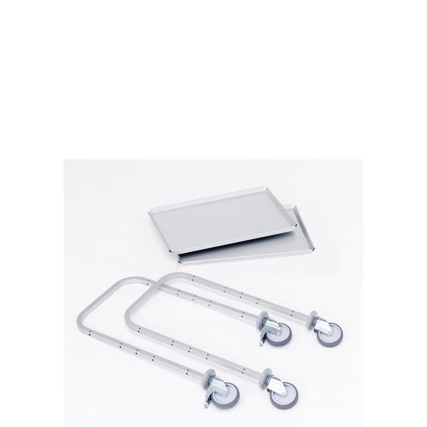 Einzelteile für einen Rollwagen bestehend aus zwei Metallböden und zwei U-förmigen Rahmen mit Lenkrollen.