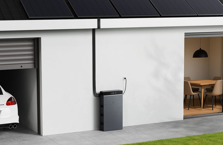 Modernes Heimspeichersystem für Solarenergie an einer weißen Hauswand, verbunden mit Photovoltaikmodulen auf dem Dach neben einer Garage.