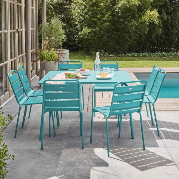 Türkisfarbenes Gartenmöbel-Set aus Metall mit quadratischem Tisch und sechs Stühlen auf einer hellen Steinterrasse am Pool.