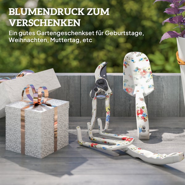 Gartenset mit Blumendruck, bestehend aus Gartenschere, Handschaufel und Gartenkralle, neben einem Geschenk