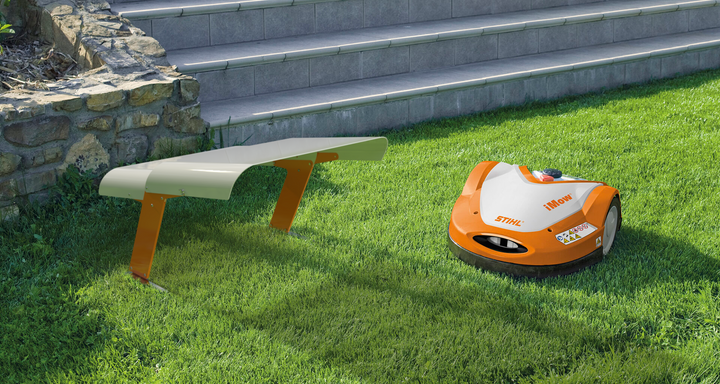 Rasenroboter mit Garage auf einer Rasenfläche