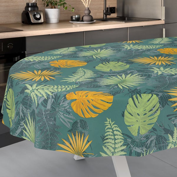 Tischdecke mit tropischem Blattmuster aus Monstera und Farnen in einer modernen Küche.