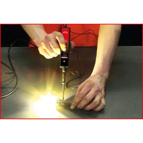 Eine Person testet mit einem Spannungsprüfer eine elektrische Verbindung, bei der ein Funke entsteht.