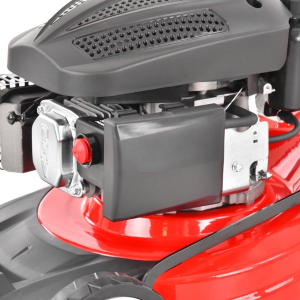 Detailansicht eines Benzinrasenmähers mit Motor, rotem Primerknopf, Luftfiltergehäuse und Zylinderkopf.