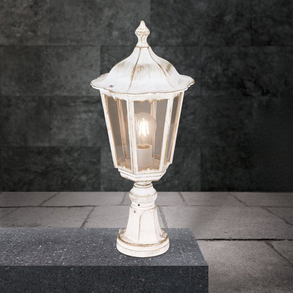 Weiß-goldene Außenleuchte im Vintage-Stil, Sockelleuchte aus Metall und Glas mit dekorativem Gehäuse und sichtbarem Leuchtmittel.