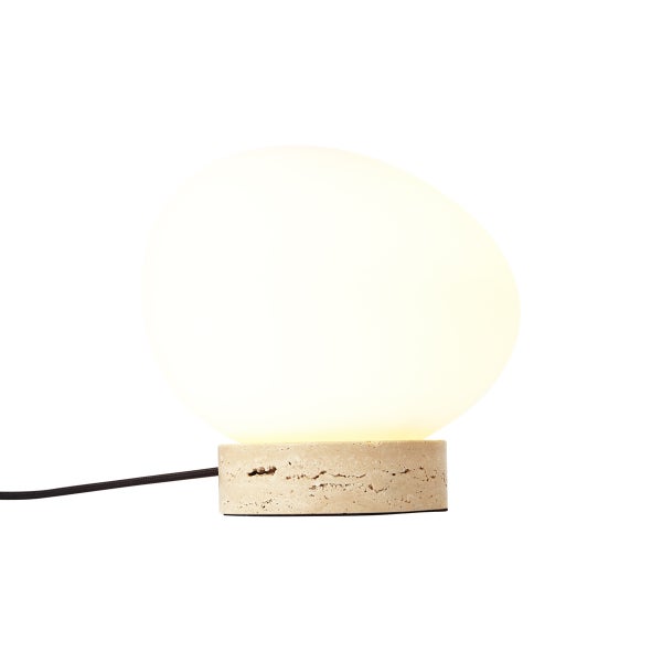 Moderne Tischleuchte mit organisch geformtem Glasschirm und rundem Sockel in Steinoptik.