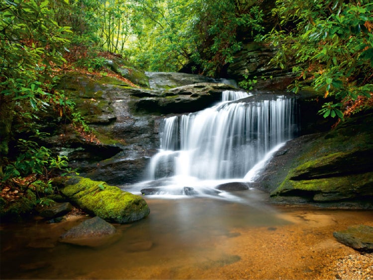 Wasserfall zwischen Felsen und Vegetation