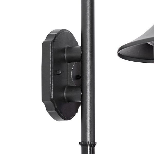 Detailansicht einer Wandhalterung für eine Außenleuchte aus schwarzem Metall mit verzierter Halteplatte.