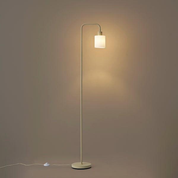 Stehleuchte mit gebogenem Arm, zylindrischem Schirm aus geriffeltem Glas und Fußschalter.