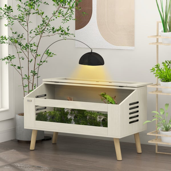 Modernes Terrarium aus hellem Holz mit Glasfront und Belüftungsschlitzen. Einrichtung mit Moos und Chamäleon unter schwarzer Bogenlampe. PawHut Logo.