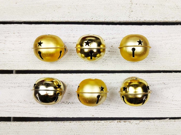 Set aus sechs runden Metallglöckchen mit Sternausstanzungen zur Dekoration.