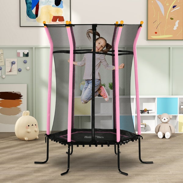 Ein Mädchen springt auf einem Kindertrampolin mit Sicherheitsnetz in einem hellen Raum.