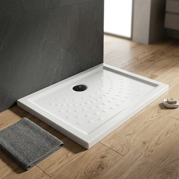 Rechteckige Duschwanne mit rutschhemmender Noppenstruktur und schwarzem Ablauf in einem modernen Badezimmer mit Holzboden und Schieferwand.