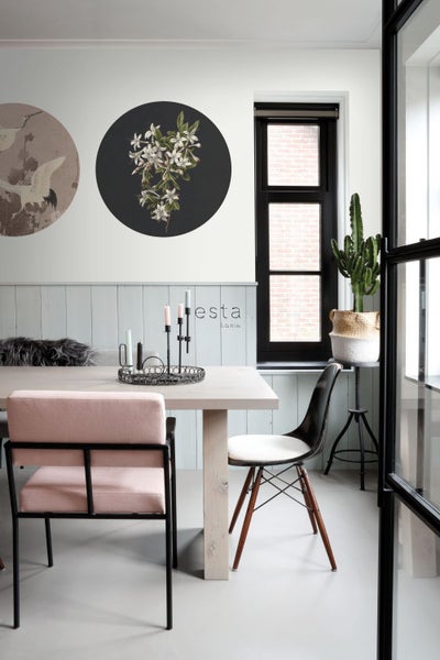 Esszimmer mit Esstisch, Stühlen, Wanddekoration und Zimmerpflanze