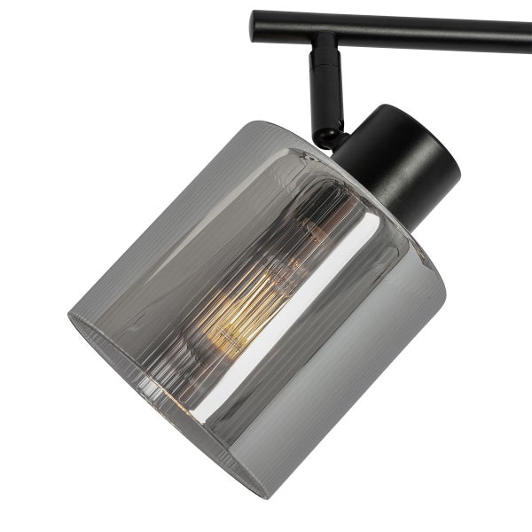Strahler an schwarzer Metallschiene mit zylindrischem Lampenschirm aus geriffeltem Rauchglas und sichtbarem Leuchtmittel