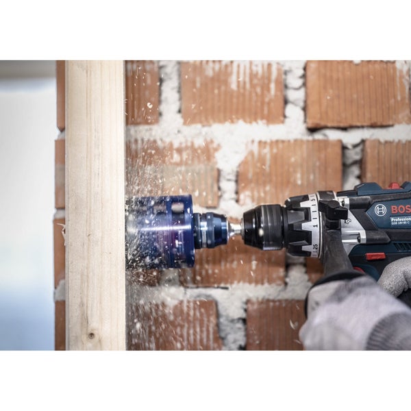 Mann benutzt eine Kappsäge auf einer Baustelle, um ein Werkstück zu bearbeiten.