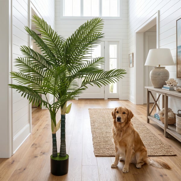 Große künstliche Palme in einem hellen Flur mit Holzboden, Wandpaneelen, einem Hund und einem Konsolentisch.