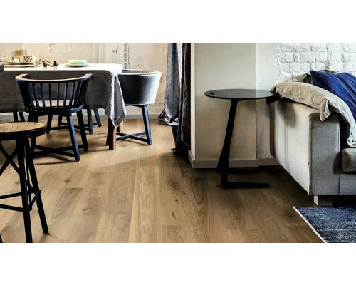 Wohnraum mit Esstisch, Stühlen, Sofa und hellem Holzboden.